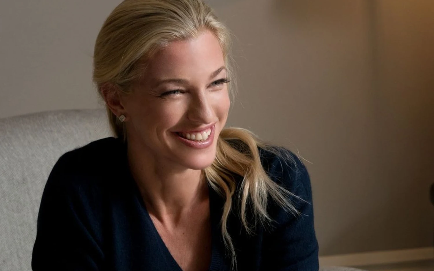 Nicole Junkermann seated in a pale armchair in a navy jumper, smiling to one side Nicole Junkermann seated in a pale armchair in a navy jumper, smiling to one side